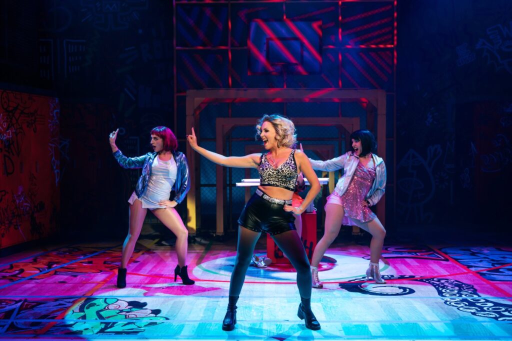 Drei Darstellerinnen in pinkem Licht im Musical FACK JU GÖHTE