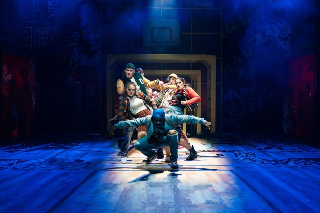Tanzgruppe in blauem Bühnenlicht im Musical FACK JU GÖHTE